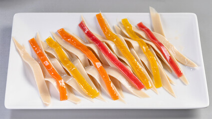 Colorful strips of jelly dessert showcase artistic flair on a plate