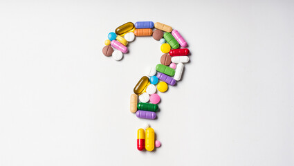 Colorful assortment of pills arranged in a question mark shape