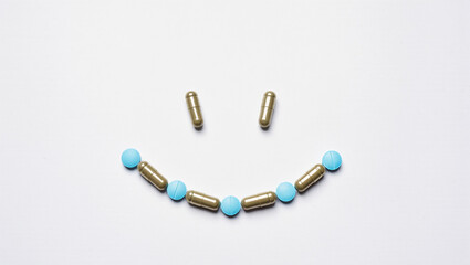 Happy smiley face made with colorful pills on a clean surface