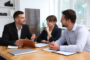 Couple having meeting with business consultant at table in office