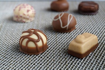 several assorted chocolate candies on a gray background