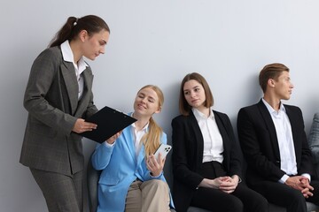 People waiting in queue on chairs indoors