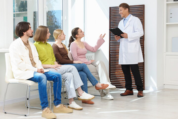 Fototapeta premium People waiting in queue on chairs at hospital