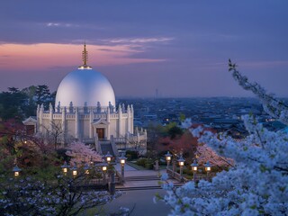 Obraz premium White domed Buddhist temple surrounded by cherry blossoms at twilight pagoda