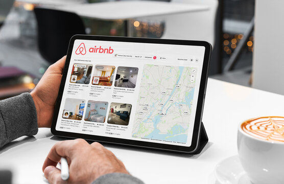 Businessman using airbnb app on tablet in new york city cafe