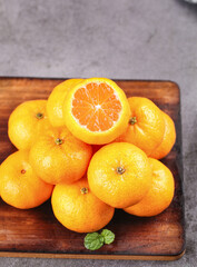 Fresh Tangerines on Wooden Board with Cut Half Showing Orange Segments
