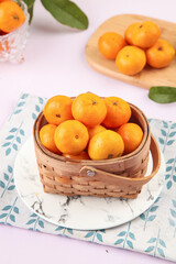 Fresh Small Orange Citrus Fruits from Guangxi in Wicker Basket on Marble Plate