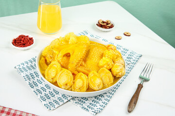 Golden Chicken Soup with Dumplings and Healthy Ingredients Table Setting