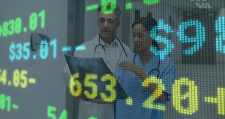 Reviewing clinicians in lab coat and scrubs analyzing X-ray film in hospital hall with data overlay