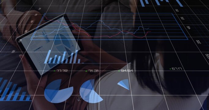 Leaning professionals examining tablet showing bar pie charts on office table with wireframe grid