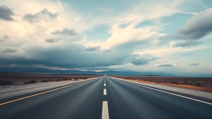 Fototapeta premium Panoramic view of an empty road under cloudy skies, capturing a serene and open landscape.