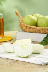 Fresh Green Apple Slices with Honey and Basket of Whole Apples on Kitchen Counter