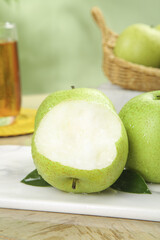 Fresh Green Pears with Sliced Fruit Showing White Flesh on Kitchen Counter
