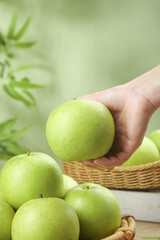 Fresh Green Apple in Hand - Organic Fruit Harvest Closeup with Natural Background