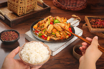 Spicy Stir-Fried Chicken with Rice and Traditional Asian Seasonings on Wooden Table