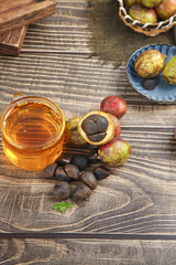 Camellia Tea Oil with Seeds and Nuts on Wooden Table - Natural Harvest and Traditional Oil Extraction