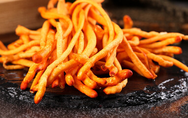 Golden Cordyceps Sinensis Chinese Traditional Herbal Medicine Mushrooms on Dark Stone Surface