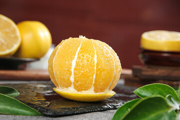 Fresh Peeled Taiwan Pomelo Grapefruit Segments on Dark Slate with Green Leaves