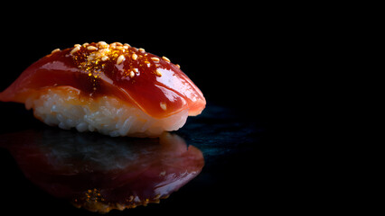 A single piece of gourmet tuna sushi on a black background with reflections. Minimalist culinary style, elegant Japanese presentation, and refined delight.