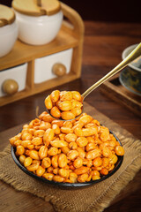 Large Bowl of Crispy Roasted Peanuts with Golden Spoon on Rustic Wooden Table
