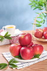 Fresh Red Fuji Apples from Xinjiang China on Rustic Kitchen Table with Tea Cup and Wicker Basket