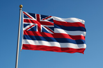 Fototapeta premium Hawaii state flag with Union Jack and red, white, blue stripesOfficial flag of Hawaii flying under a clear blue sky