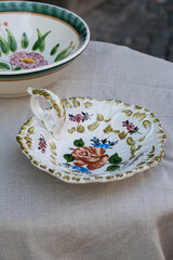 Vintage Italian plate with beautiful flower pattern on linen tablecloth.