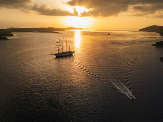 Boats and cruise ships in the Mediterranean Sea off the coast of Hvar Croatia during sunset, drone photo