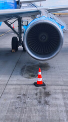 Jet engine and safety cone on airport tarmac
