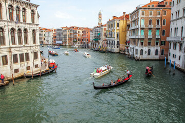 Scenic view of Grand Canal in Venice, Italy, with gondolas, boats and historic architecture. Popular tourist destination and romantic cityscape.
