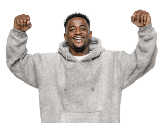 Happy young man in a gray hoodie celebrating success with raised fists, showing joy, confidence, and a positive attitude.
