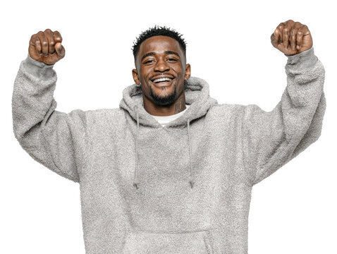 Happy young man in a gray hoodie celebrating success with raised fists, showing joy, confidence, and a positive attitude.