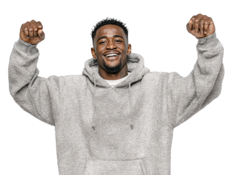 Happy young man in a gray hoodie celebrating success with raised fists, showing joy, confidence, and a positive attitude.
