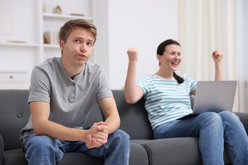 Obraz premium Man feeling jealous of woman's success at home, selective focus