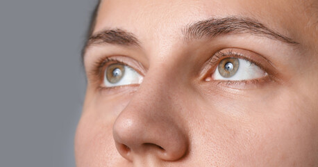 Fototapeta premium Woman with beautiful eyes on light grey background, closeup