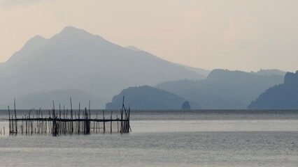 A mountain-backed lagoon with a wooden pier
