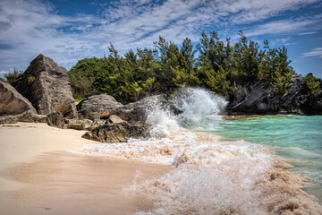 Serene Jobson's Cove, Bermuda: Crystal-Clear Turquoise Waters, Sandy Shore, and Rocky outcrops Under a Bright Blue Sky with Scattered Clouds