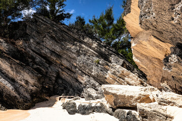Serene Jobson's Cove, Bermuda: Crystal-Clear Turquoise Waters, Sandy Shore, and Rocky outcrops Under a Bright Blue Sky with Scattered Clouds