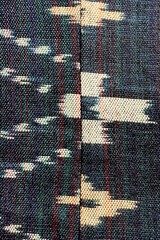 Handwoven ikat textile featuring colorful geometric patterns. Perfect for backgrounds, fashion, interior design, and cultural themes.