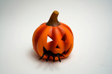 Halloween jack-o-lantern with spider crawling out from bottom symbolizing spooky horror decoration, fear, and dark festive mystery.