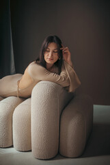 Obraz premium Young thoughtful woman in a long dress in the studio. Light thoughtfulness and dreaminessaa