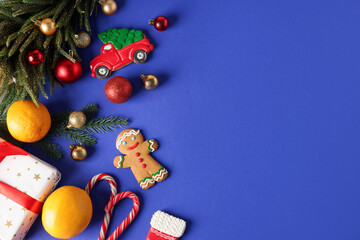 Saint Nicholas day. Fir tree, ornaments, gift box and treats on blue background, flat lay. Space for text