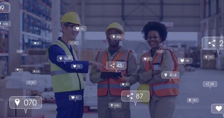Warehouse workers pointing tablet and activating floating social icons showing counters rising - Powered by Adobe