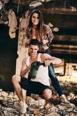 Young couple posing playfully during construction in a partially demolished building site