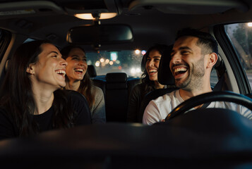 young friends enjoying laughter and conversation during a night drive in the city