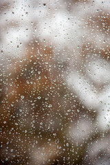 Close-up of water droplets on a window glass, creating a blurred effect. Perfect for weather, rain, or natural water texture imagery.