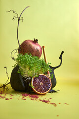 Creative still life with exotic fruits and vegetables arranged in artistic composition on yellow background. Minimalist style, healthy eating, organic food, modern art concept