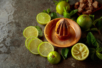 Wooden citrus squeezer and ingredients for making summer refreshing drinks.