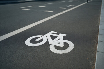 Fototapeta premium Señal de carril bici pintada en el asfalto de una vía urbana con línea blanca lateral