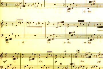 Fototapeta premium Vintage sheet music notation manuscript with staff lines and gently moving musical notes. This retro, grunge styled motion background is a seamless loop.
